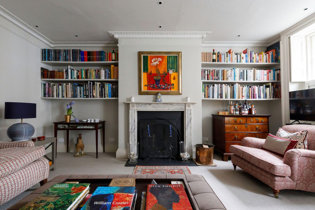 Gilbert House West Sussex lounge with book-lined fireplace