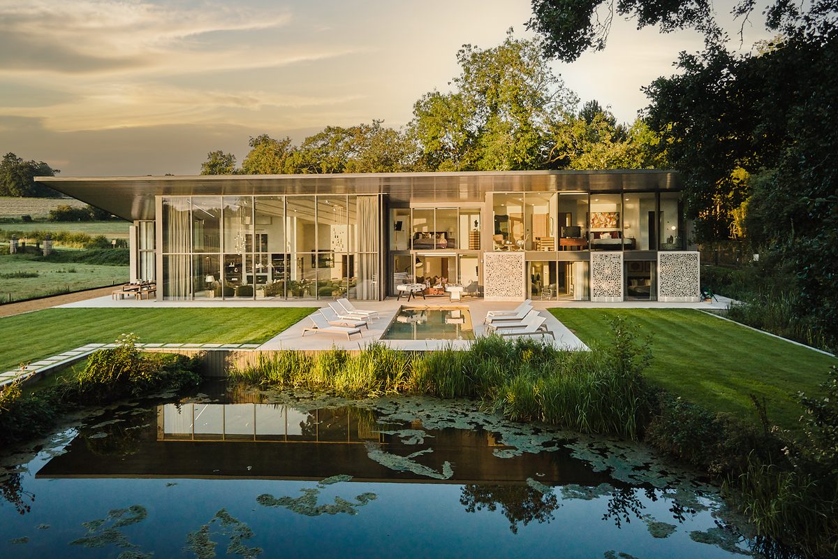 The Waterside Retreat Hampshire exterior with pond at dusk